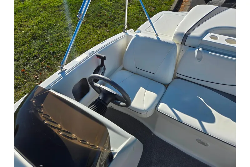 Slide: The Image of 2011 Bayliner 197 boat interior with white seating and steering wheel. - 19