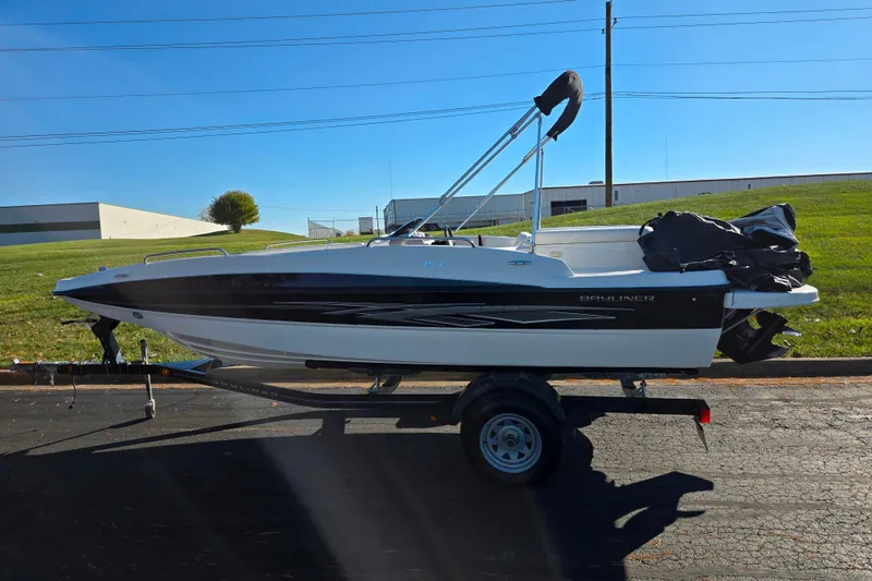 Slide: The Image of 2011 Bayliner 197 boat on trailer, parked outdoors on a sunny day. - 4