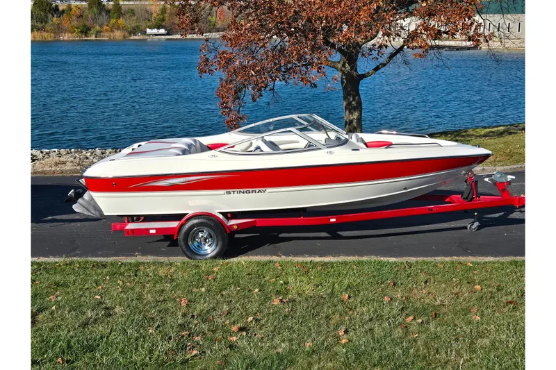 The Image of 2005 Stingray 195 LR boat on trailer by a lake in autumn setting. - 0