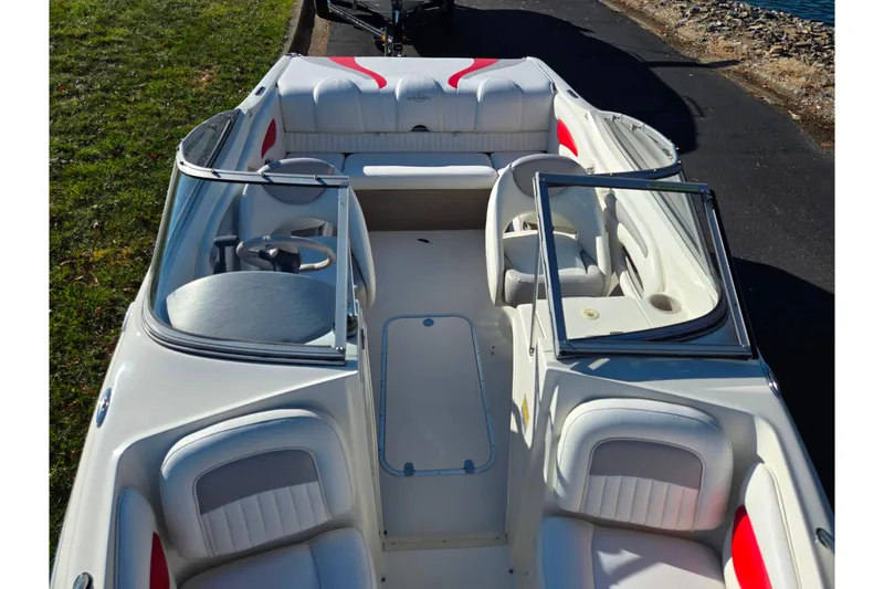 Slide: The Image of 2005 Stingray 195 LR boat interior with white and red seating, docked by the water. - 19