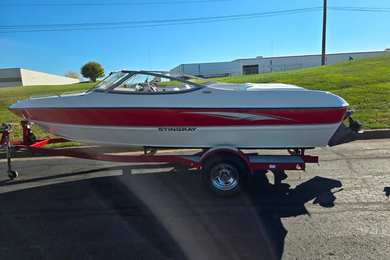 Slide: The Image of 2005 Stingray 195 LR boat on trailer, red and white design, parked outdoors. - 4