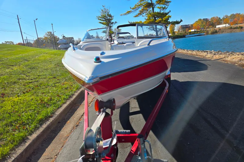 Slide: The Image of 2005 Stingray 195 LR boat on trailer by a lakeside road. - 6