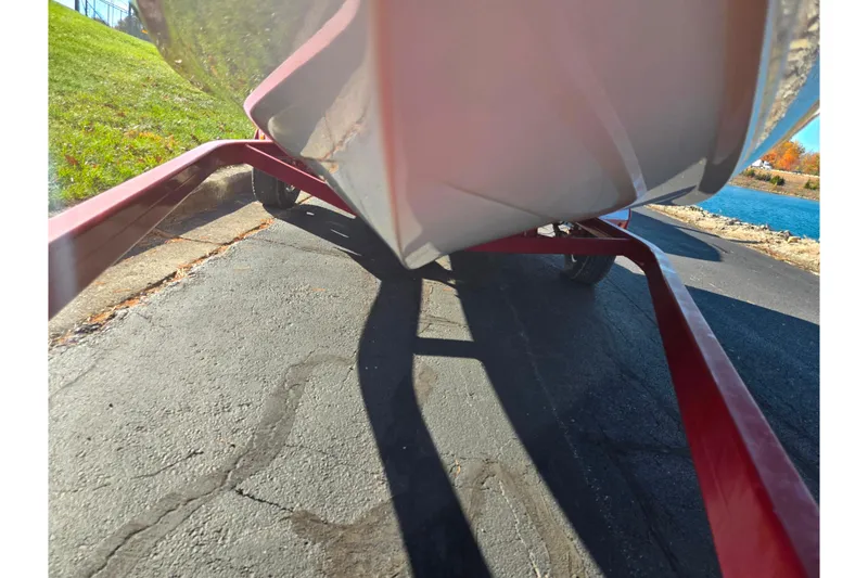 Slide: The Image of 2005 Stingray 195 LR boat on red trailer near a lake. - 7