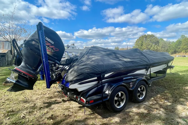 The Image of 2013 Skeeter FX21 boat with Yamaha motor, covered and parked on grass under a blue sky. - 0