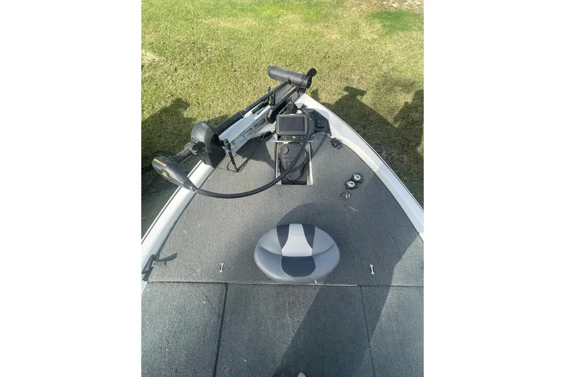 Slide: The Image of 2013 Skeeter FX21 boat deck with fishing equipment and seat on grassy background. - 3