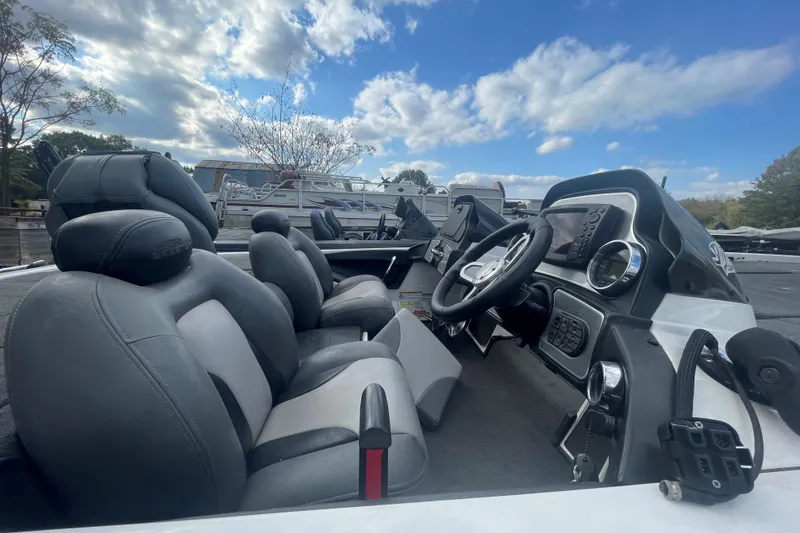 Slide: The Image of 2013 Skeeter FX21 boat interior with steering wheel and seats under a cloudy sky. - 6