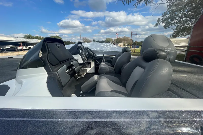 Slide: The Image of 2013 Skeeter FX21 boat interior with gray seats under a blue sky. - 7