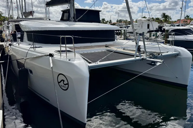 The Image of 2020 Lagoon 42 catamaran docked at marina under a partly cloudy sky. - 0