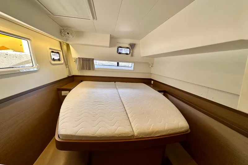 Slide: The Image of Cozy cabin interior of 2020 Lagoon 42 catamaran with comfortable bed and windows. - 13