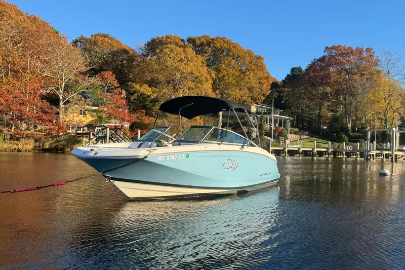 The Image of 2017 Regal 23 OBX boat on calm lake with autumn trees in the background. - 1