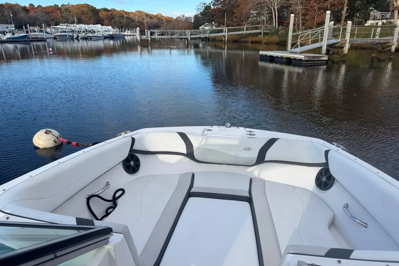 Slide: The Image of 2017 Regal 23 OBX boat interior on calm water near a dock. - 10