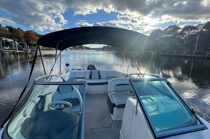 Slide: The Image of 2017 Regal 23 OBX boat on a serene river under a cloudy sky. - 14