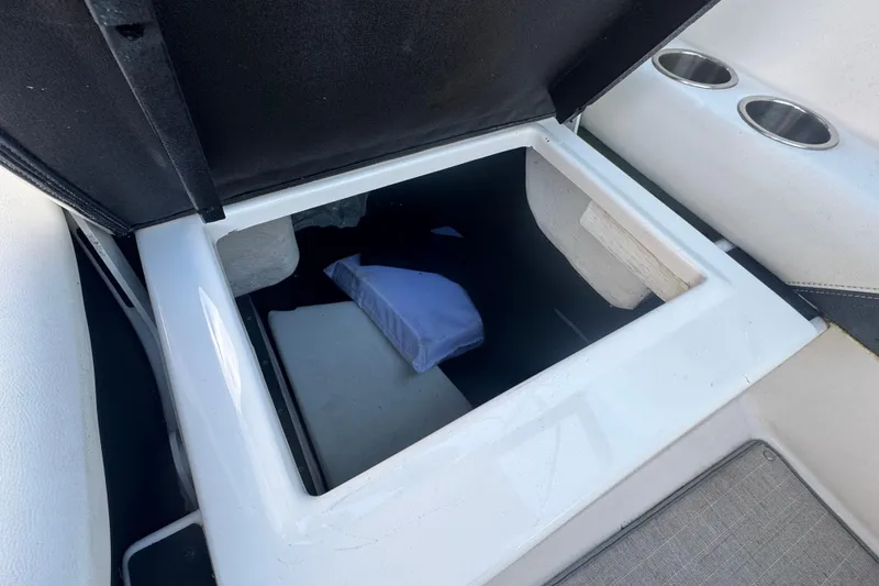 Slide: The Image of Open storage compartment on 2017 Regal 23 OBX boat with cup holders. - 16