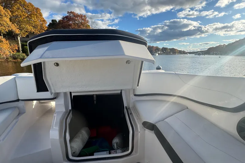 Slide: The Image of 2017 Regal 23 OBX boat interior with open storage compartment, scenic lake view. - 17