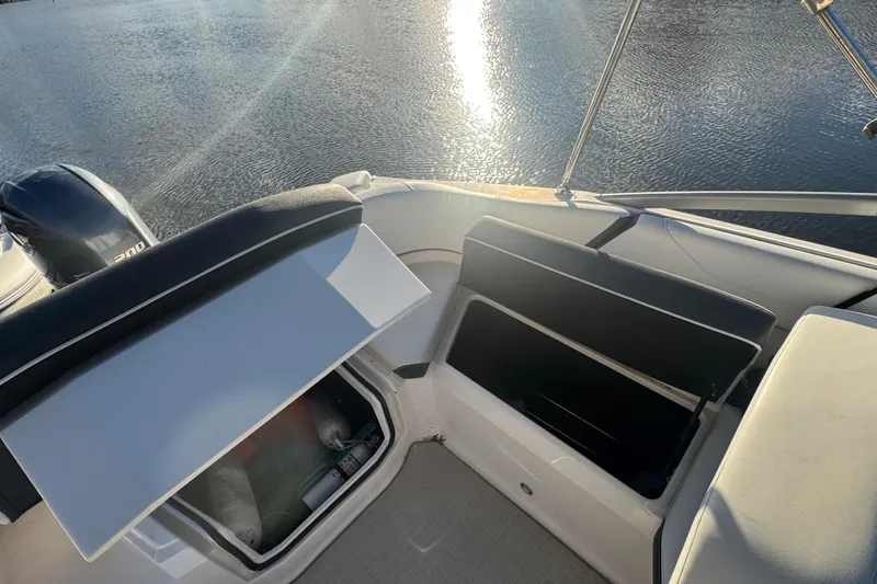 Slide: The Image of 2017 Regal 23 OBX boat interior with open storage compartments on a sunny day. - 18