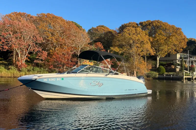 Slide: The Image of 2017 Regal 23 OBX boat on calm water, surrounded by autumn trees. - 2