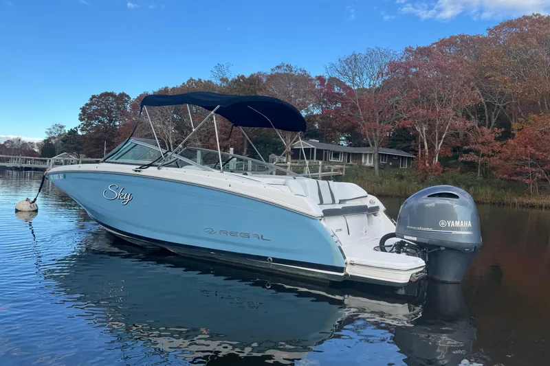 Slide: The Image of 2017 Regal 23 OBX boat with Yamaha engine on calm water, surrounded by autumn trees. - 4