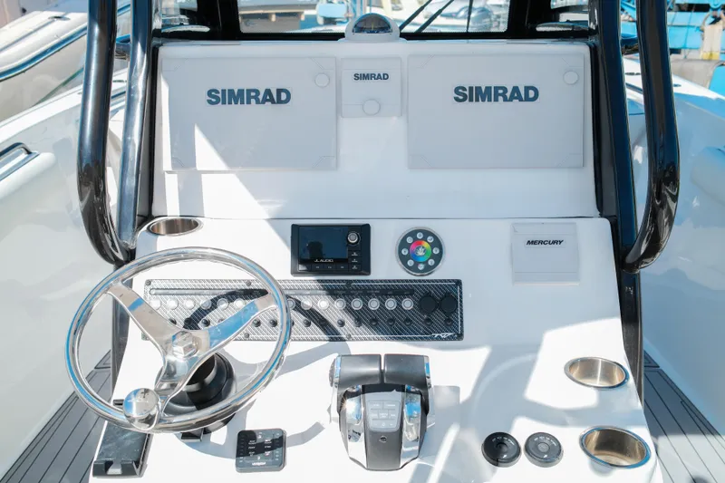 Slide: The Image of 2021 Tidewater 292 CC Adventure boat dashboard with Simrad electronics and Mercury controls. - 14
