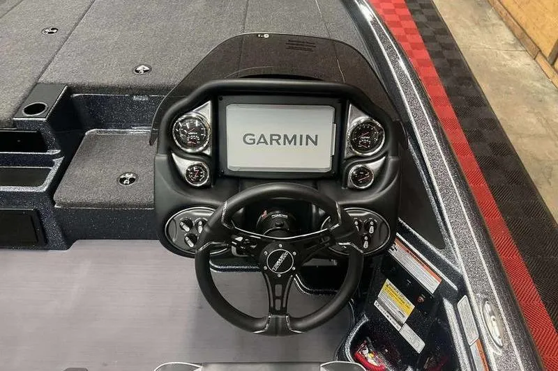Slide: The Image of 2026 Triton 19 TrX Patriot boat dashboard with Garmin display and steering wheel. - 2