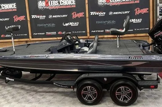 Slide: The Image of 2026 Triton 19 TrX Patriot boat in showroom, rear view with powerful engine. - 7