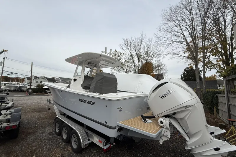Slide: The Image of 2026 Regulator 28 boat with Yamaha engine on trailer, parked outdoors. - 6