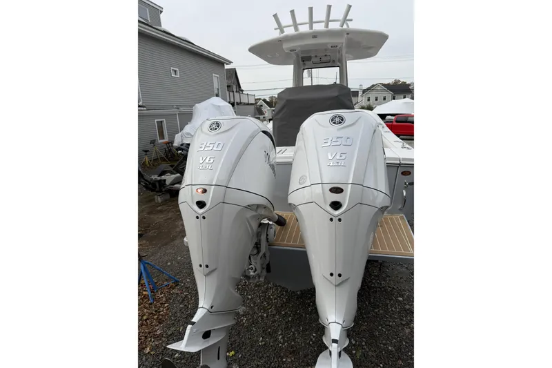 Slide: The Image of 2026 Regulator 28 boat with twin 350 V6 outboard engines, parked outdoors. - 8