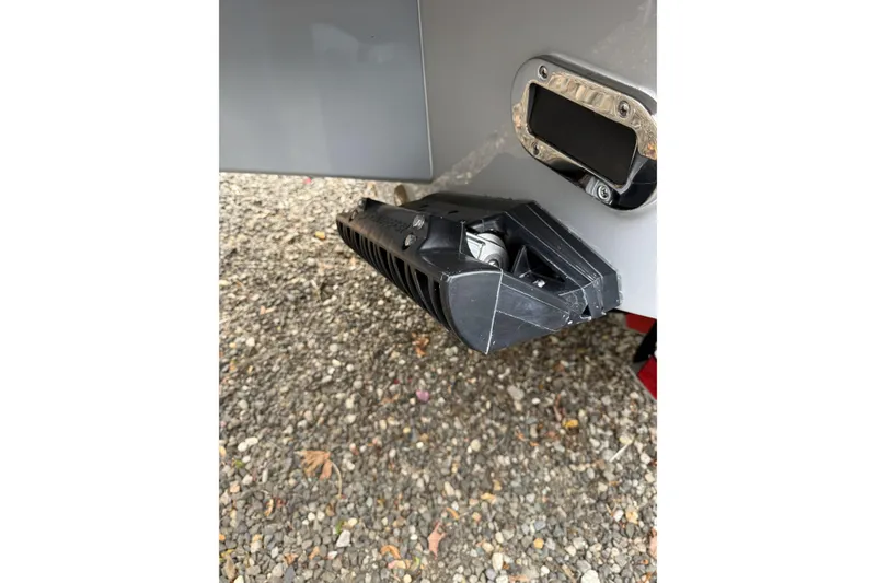 Slide: The Image of 2026 Regulator 28 boat detail showing trim tab on gravel surface. - 9