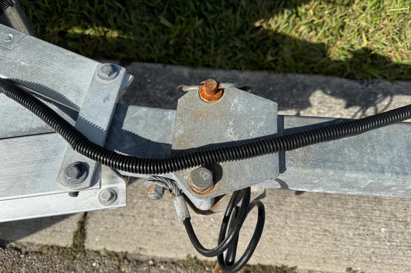 Slide: The Image of Trailer hitch detail of a 2017 Key West 189 FS boat, showing bolts and wiring. - 100