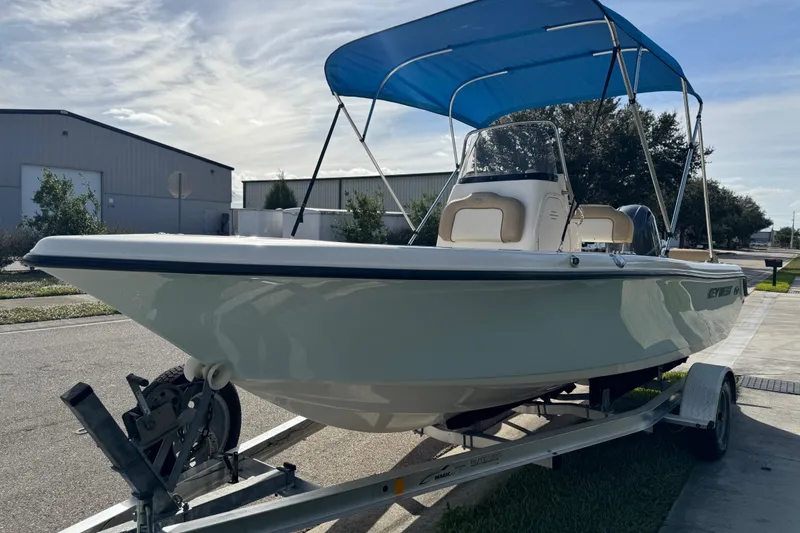Slide: The Image of 2017 Key West 189 FS boat on trailer, featuring beige seating and a blue canopy. - 20