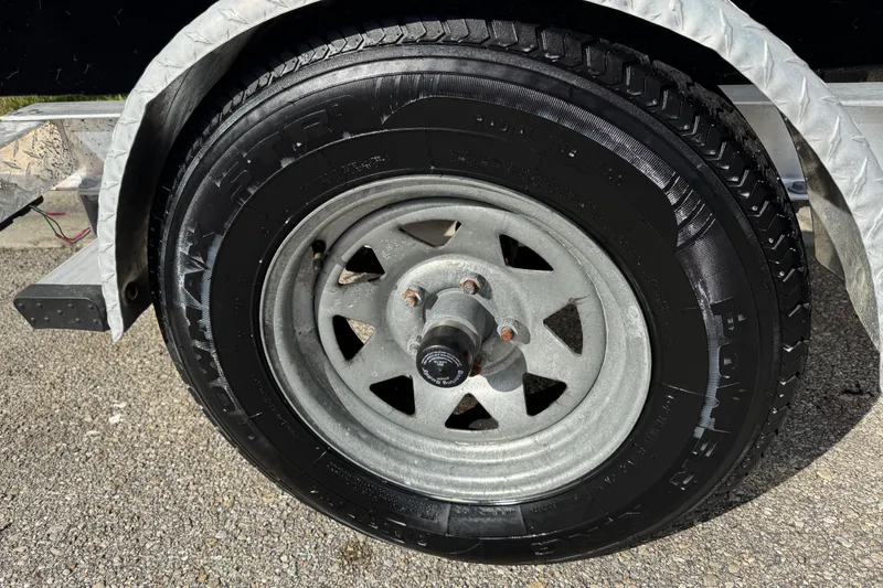 Slide: The Image of Trailer wheel of a 2017 Key West 189 FS boat on asphalt surface. - 4