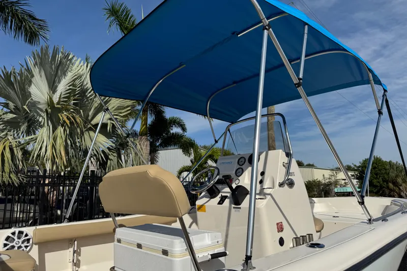 Slide: The Image of 2017 Key West 189 FS boat with blue canopy and palm trees in background. - 88