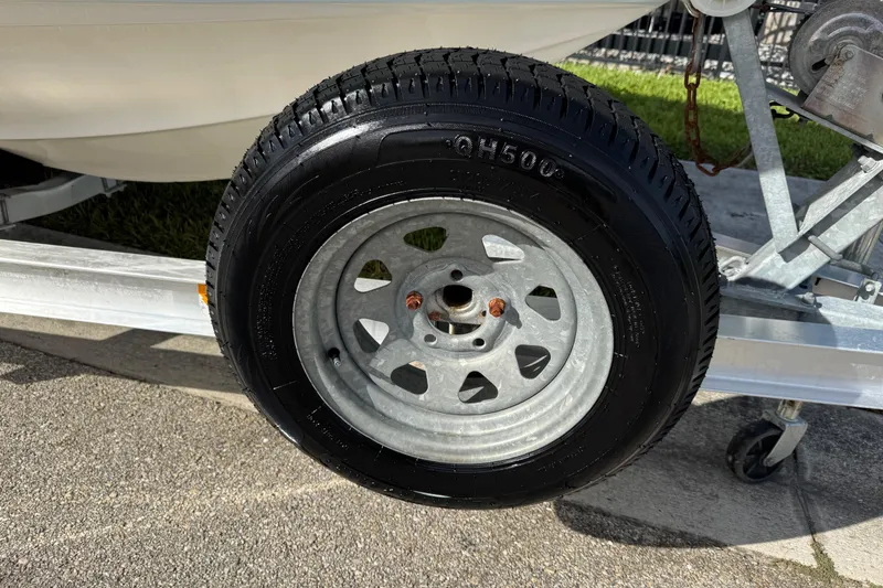 Slide: The Image of Trailer wheel of a 2017 Key West 189 FS boat on pavement. - 98