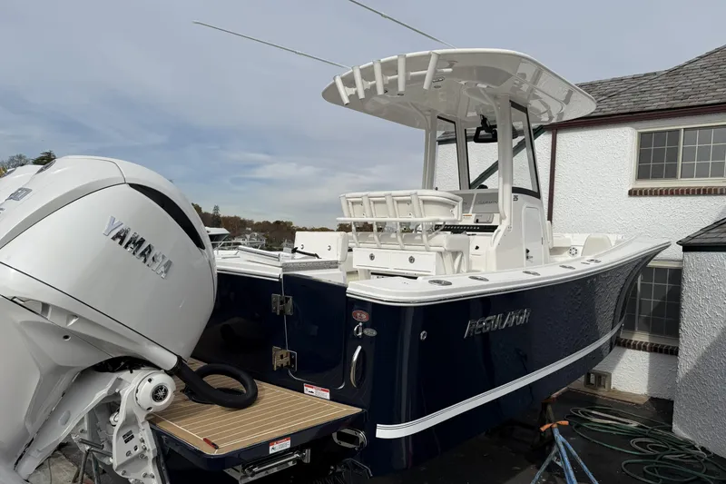Slide: The Image of 2026 Regulator 25 boat with Yamaha engine, docked near a building. - 1