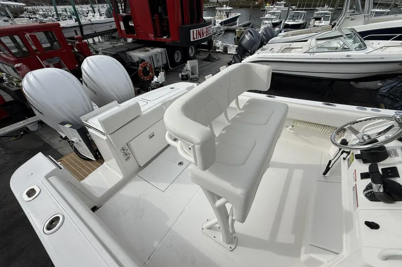 Slide: The Image of 2026 Regulator 25 boat interior with dual engines and white seating at marina. - 12