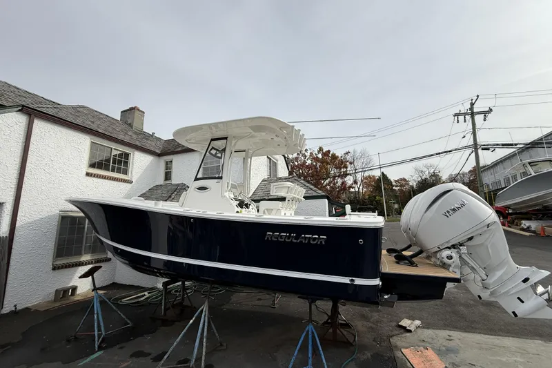 Slide: The Image of 2026 Regulator 25 boat with Yamaha engine on stands, outdoor setting. - 3