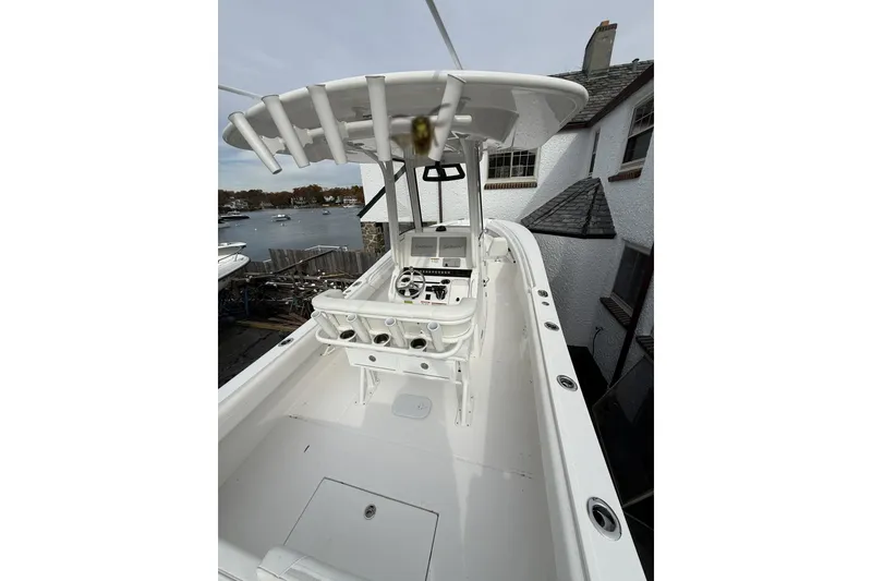 Slide: The Image of 2026 Regulator 25 boat with center console, docked near waterfront homes. - 7