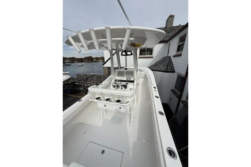 Slide: The Image of 2026 Regulator 25 boat with T-top, docked near waterfront property. - 8