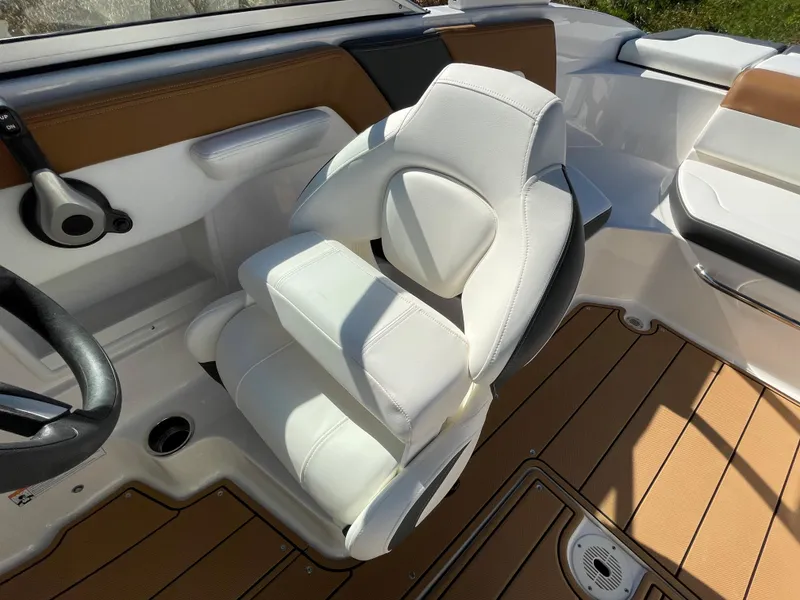 Slide: The Image of 2024 Chaparral 23 SSi OB boat interior with white captain's chair and tan flooring. - 21