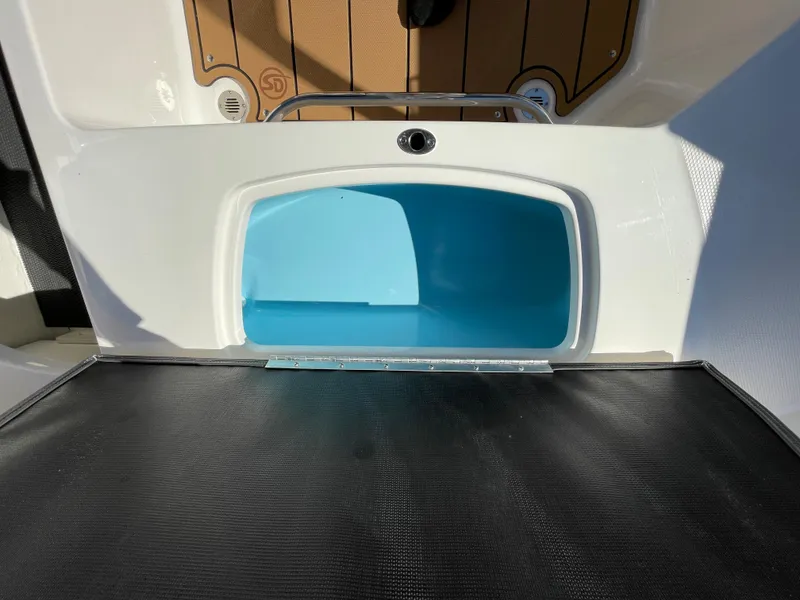 Slide: The Image of 2024 Chaparral 23 SSi OB boat storage compartment with blue interior. - 33