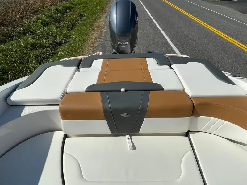 Slide: The Image of 2024 Chaparral 23 SSi OB boat with cushioned seating and outboard motor. - 39