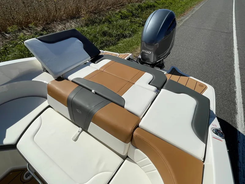 Slide: The Image of 2024 Chaparral 23 SSi OB boat with tan and white seating and outboard motor. - 42