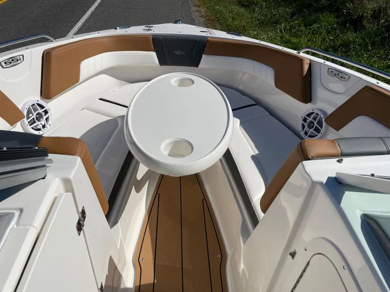 Slide: The Image of 2024 Chaparral 23 SSi OB boat interior with cushioned seating and table. - 14