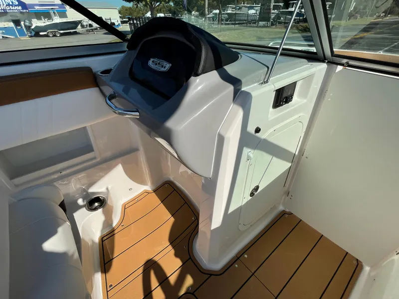 Slide: The Image of 2024 Chaparral 23 SSi OB boat interior with modern helm and teak flooring. - 24
