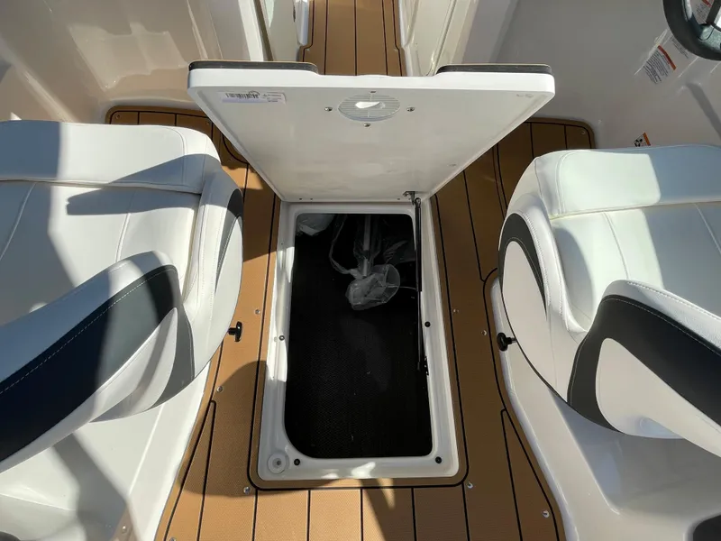 Slide: The Image of 2024 Chaparral 23 SSi OB boat interior storage compartment between seats. - 38