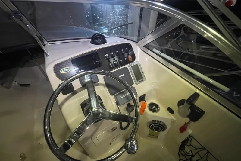 Slide: The Image of 2014 Grady-White Freedom 205 boat dashboard with steering wheel and control panel. - 11