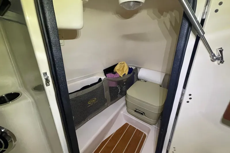 Slide: The Image of 2014 Grady-White Freedom 205 boat interior with storage and portable toilet. - 16