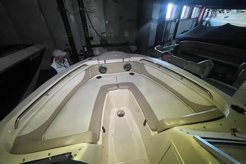 Slide: The Image of 2014 Grady-White Freedom 205 boat interior with cushioned seating in a dimly lit storage area. - 18