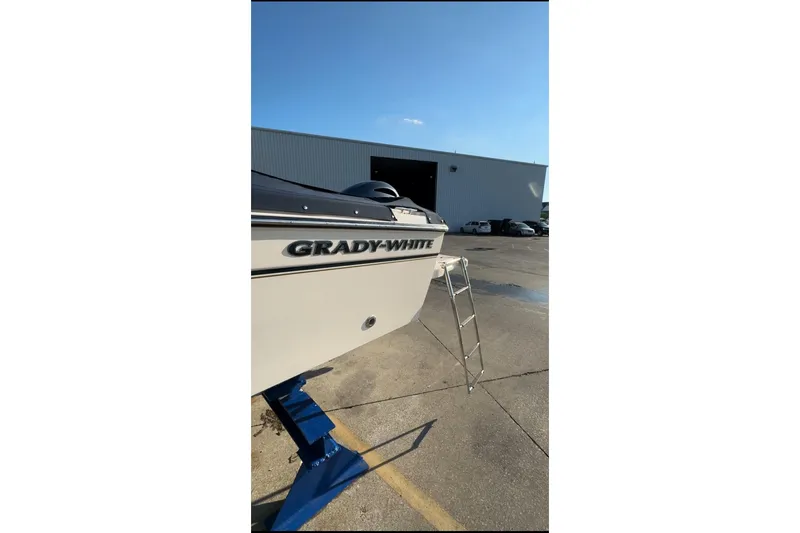 Slide: The Image of 2014 Grady-White Freedom 205 boat on stand, ladder beside, industrial background. - 2