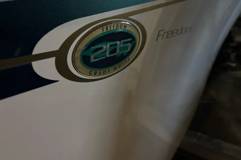 Slide: The Image of 2014 Grady-White Freedom 205 boat emblem on hull, showcasing model branding. - 24