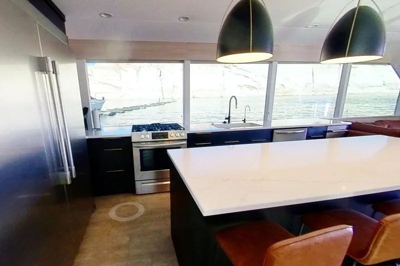 Slide: The Image of Modern kitchen in Adonia Radiance Share #3 houseboat, featuring large island, pendant lights, and scenic windows. - 6